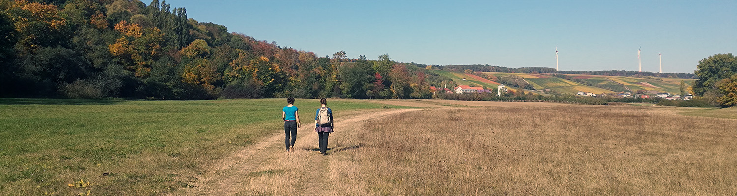 2 students walking in a field, photo by Jie Zhang
